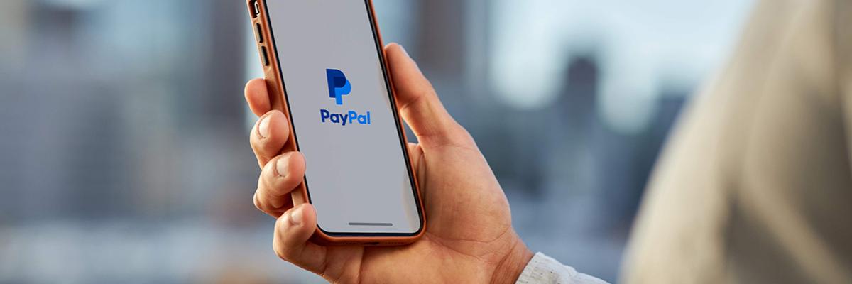 Hand hält Smartphone mit dem Logo von PayPal
